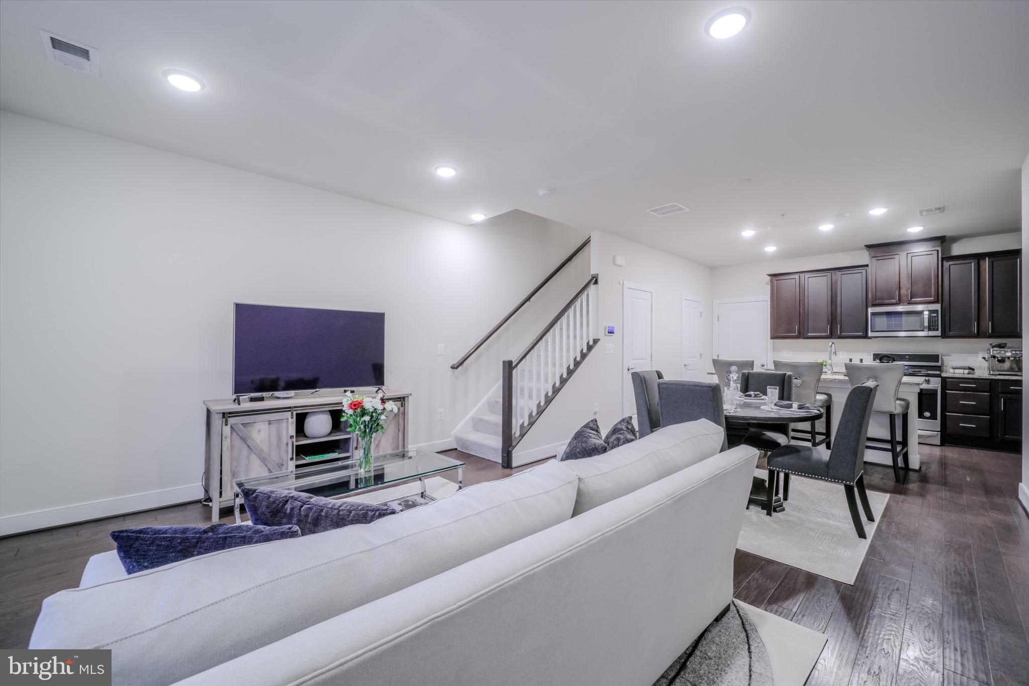 20355 Century Boulevard, Unit 177L Germantown, MD 20874 - Photo 5 of 69 a living room with furniture a kitchen view and a wooden floor