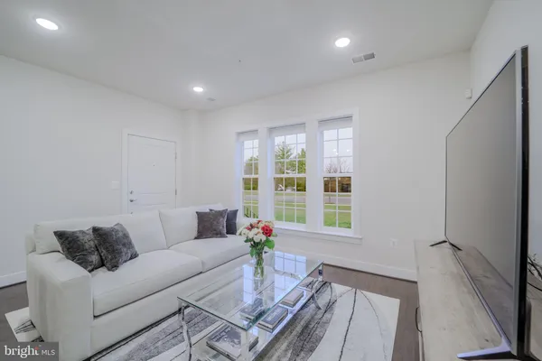 a living room with furniture a flat screen tv and a floor to ceiling window
