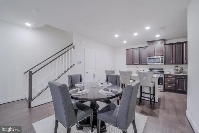 a view of kitchen with refrigerator stove dining table and chairs