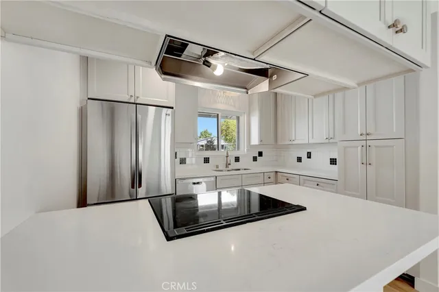 a kitchen with stainless steel appliances a sink and a refrigerator