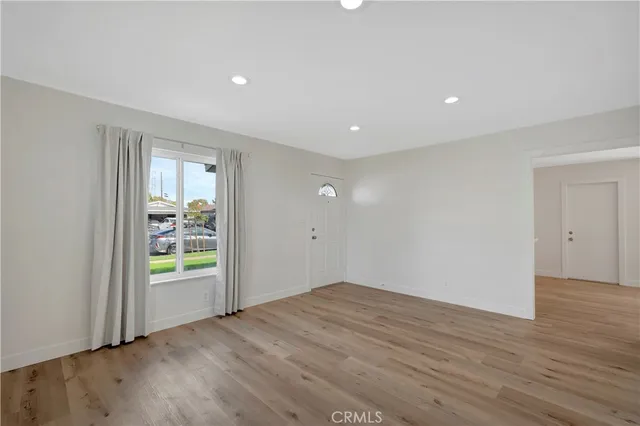 an empty room with window and wooden floor