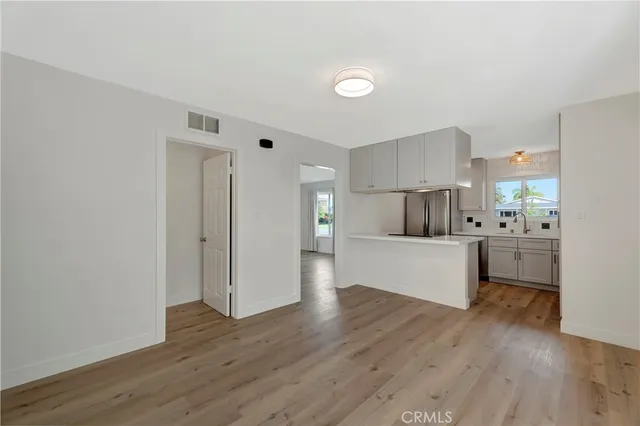 a view of kitchen with wooden floor and stainless steel appliances