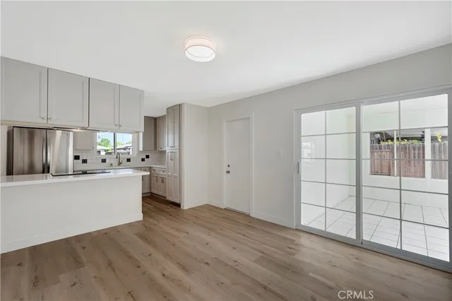 a kitchen with granite countertop a stove a sink and white cabinets