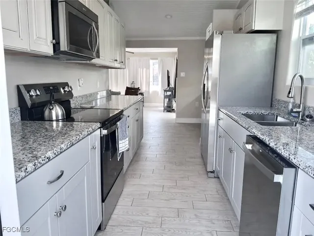 a kitchen with stainless steel appliances granite countertop a sink stove and refrigerator
