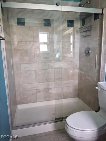 a white toilet sitting next to a bath tub