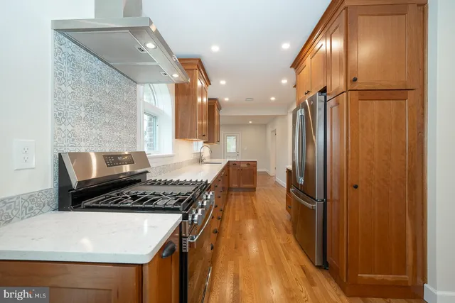 a kitchen with stainless steel appliances granite countertop a refrigerator and a stove top oven
