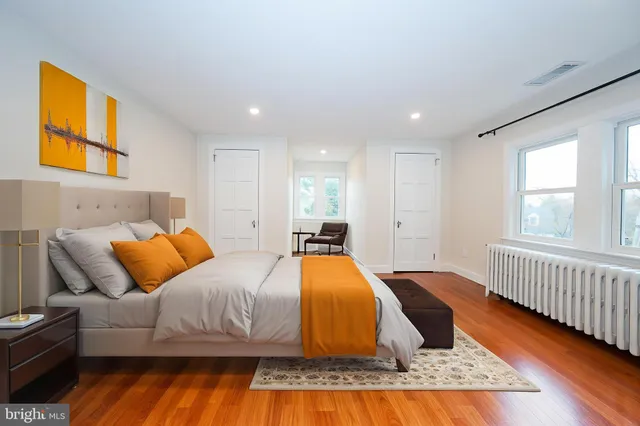 a view of an empty room with wooden floor and windows