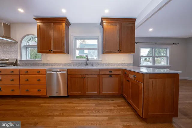 a kitchen with granite countertop a sink cabinets and stainless steel appliances