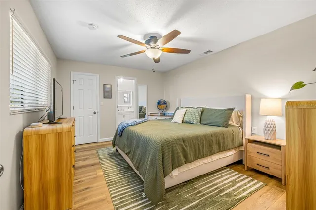a spacious bedroom with a bed and wooden floor