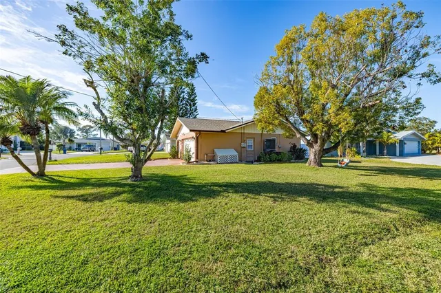 a view of a house with a big yard and large trees