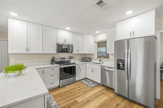 a kitchen with stainless steel appliances granite countertop a refrigerator sink and stove