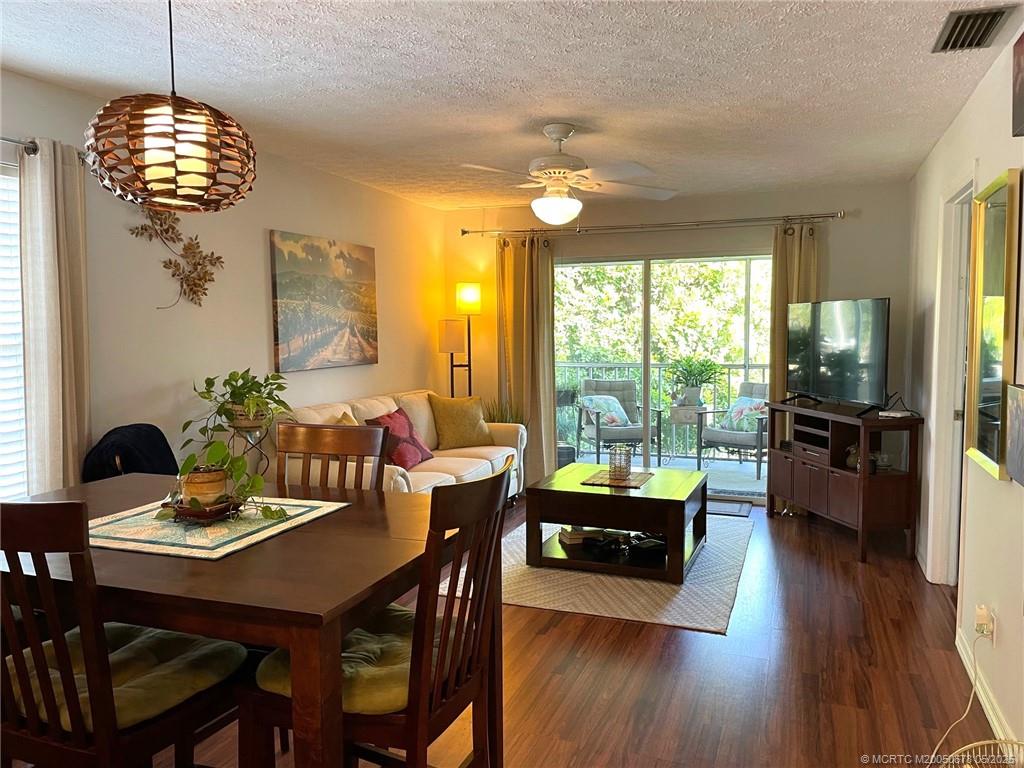 801 Southeast Central Parkway, Unit 8019 Stuart, FL 34994 - Photo 13 of 41 a view of a dining room with furniture a chandelier and wooden floor
