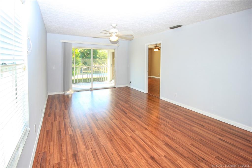 801 Southeast Central Parkway, Unit 8019 Stuart, FL 34994 - Photo 14 of 41 an empty room with wooden floor and windows