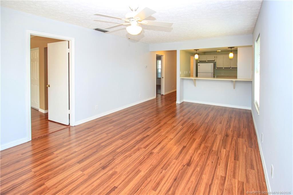 801 Southeast Central Parkway, Unit 8019 Stuart, FL 34994 - Photo 15 of 41 an empty room with wooden floor and windows