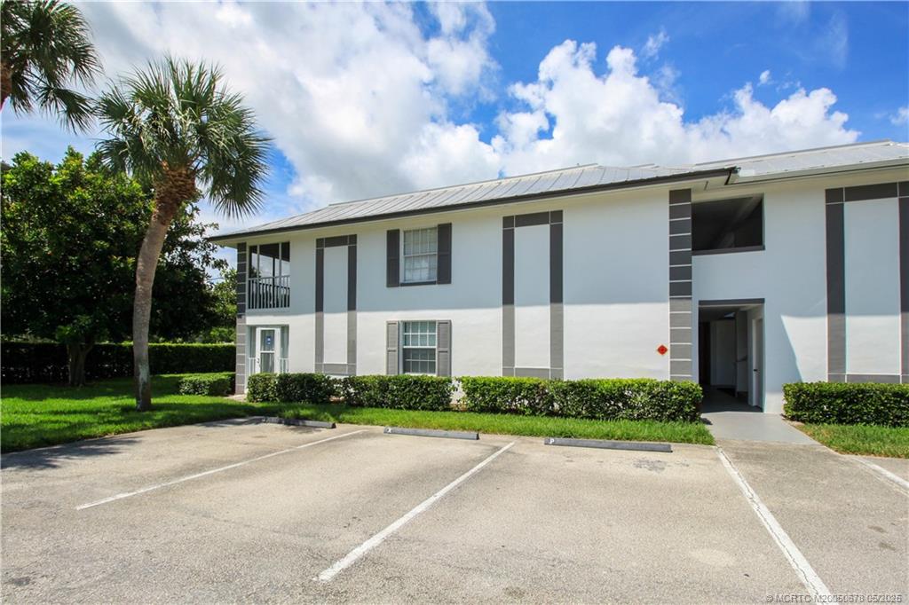 801 Southeast Central Parkway, Unit 8019 Stuart, FL 34994 - Photo 2 of 41 a front view of a house with a garden