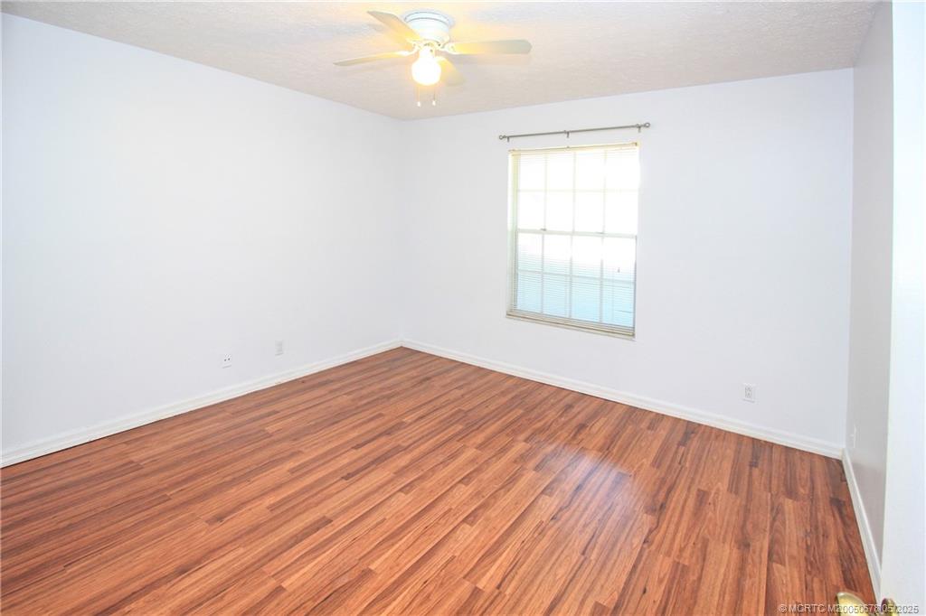 801 Southeast Central Parkway, Unit 8019 Stuart, FL 34994 - Photo 27 of 41 an empty room with wooden floor and windows