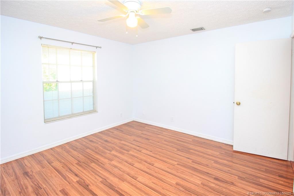 801 Southeast Central Parkway, Unit 8019 Stuart, FL 34994 - Photo 30 of 41 an empty room with wooden floor and windows
