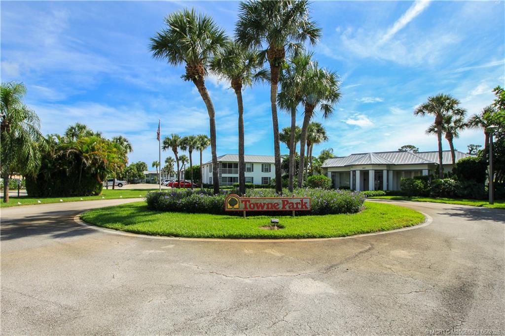 801 Southeast Central Parkway, Unit 8019 Stuart, FL 34994 - Photo 39 of 41 a front view of a house with a yard and palm trees