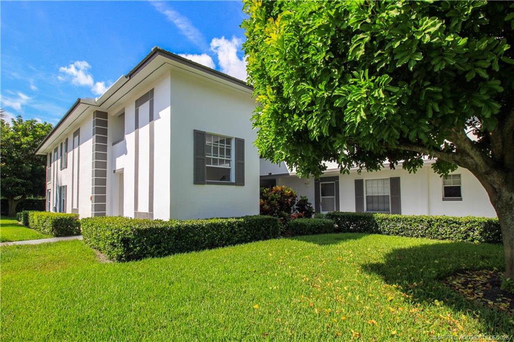 801 Southeast Central Parkway, Unit 8019 Stuart, FL 34994 - Photo 7 of 41 a front view of a house with a garden