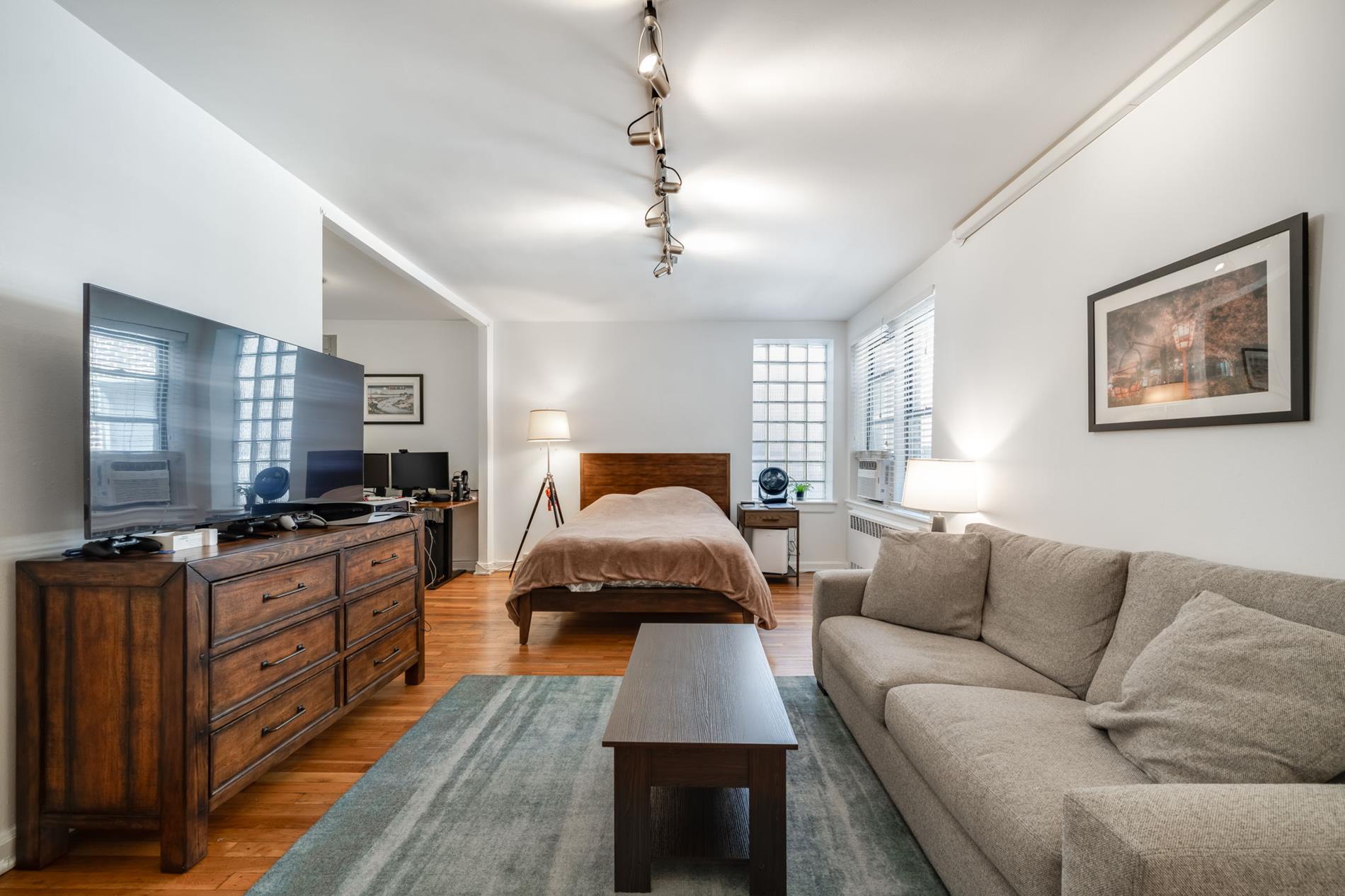 50-54 East 8th Street, Unit 6L Manhattan, NY 10003 - Photo 3 of 10 a living room with furniture and a flat screen tv