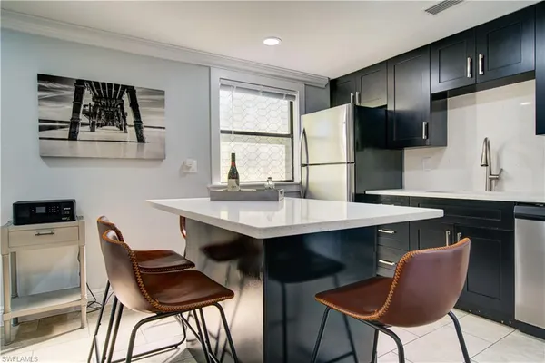 a kitchen with a table chairs refrigerator and cabinets