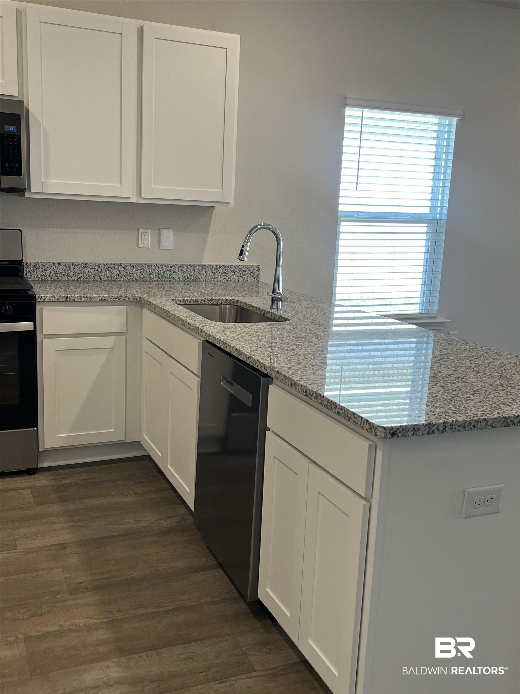 12829 Patriot Way Daphne, AL 36527 - Photo 15 of 38 Kitchen featuring white cabinets, stainless steel appliances, sink, and light stone countertops