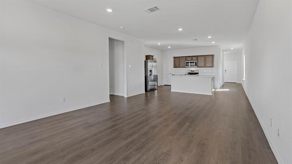 212 Pheasant Run Road Terrell, TX 75160 - Photo 21 of 24 Open-concept living space featuring wood-finish flooring, recessed lighting, white walls, and a kitchen with stainless steel appliances and wood cabinetry