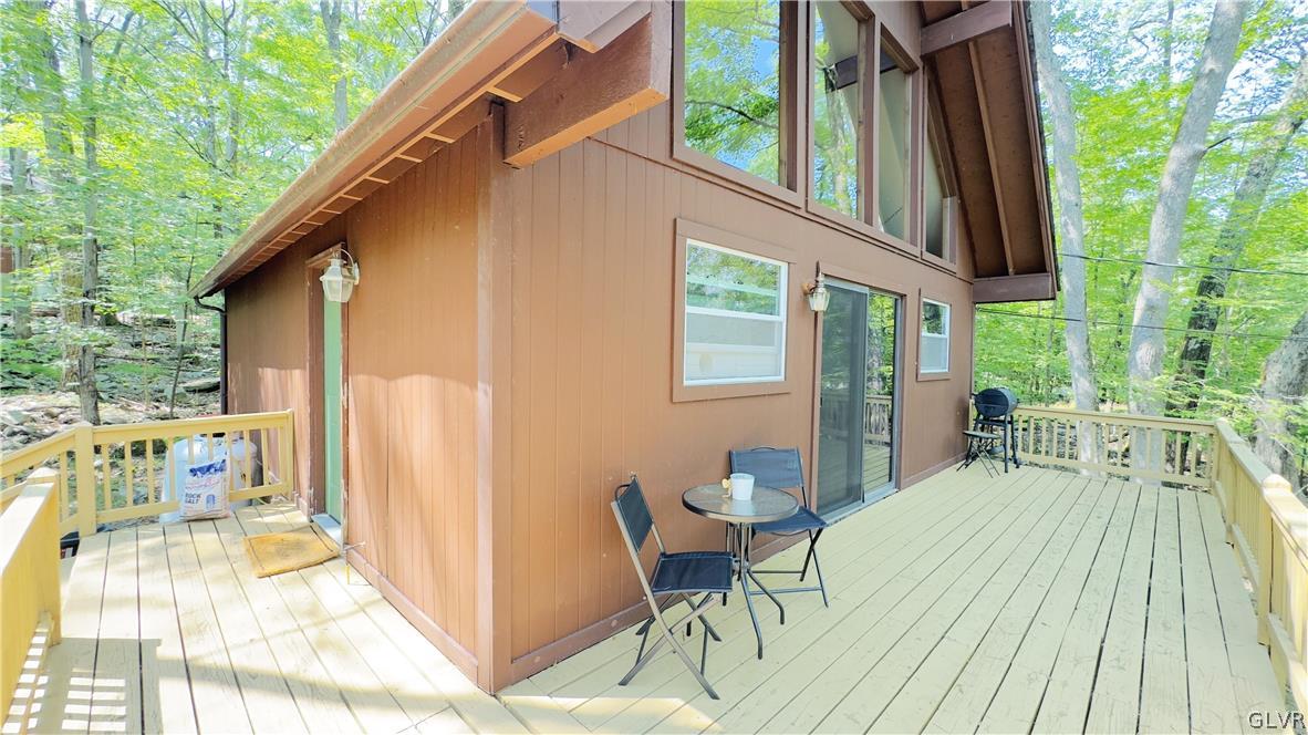 239 Saunders Drive Bushkill, PA 18324 - Photo 2 of 26 a view of a patio with table and chairs and wooden floor