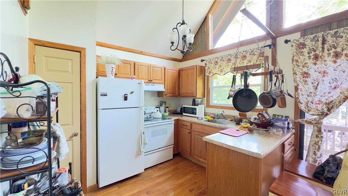 239 Saunders Drive Bushkill, PA 18324 - Photo 9 of 26 a kitchen with stainless steel appliances granite countertop a stove a refrigerator a sink a dining table and chairs with wooden floor