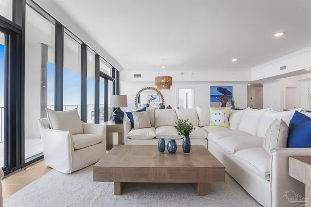 a living room with furniture and large windows