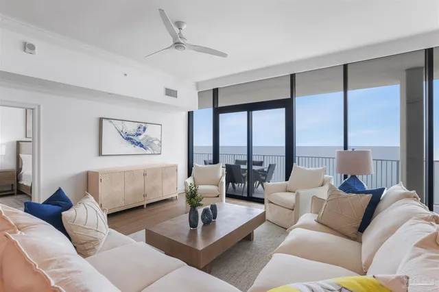 a living room with couches a coffee table and chandelier