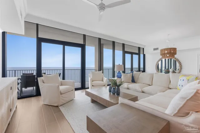a living room with furniture chandelier and a large window