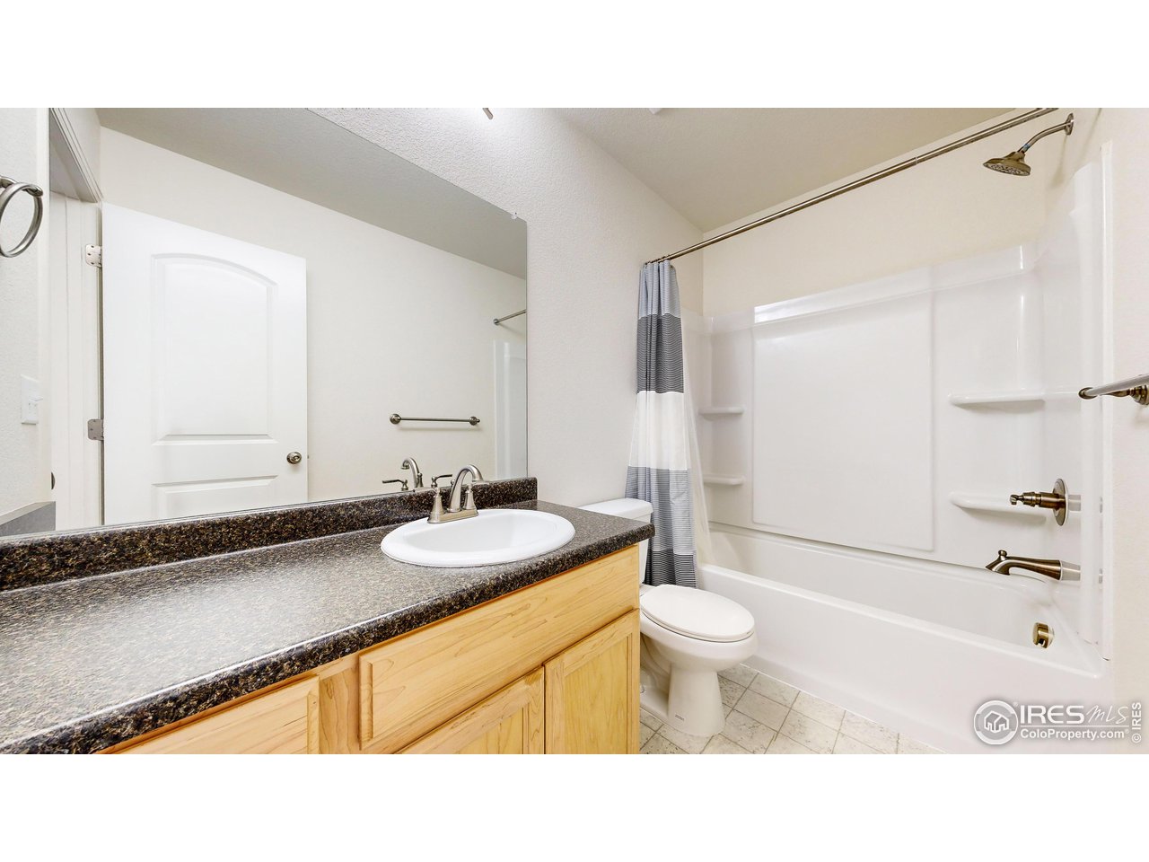 684 Takin Drive Severance, CO 80550 - Photo 21 of 38 a bathroom with a sink a toilet a mirror and shower