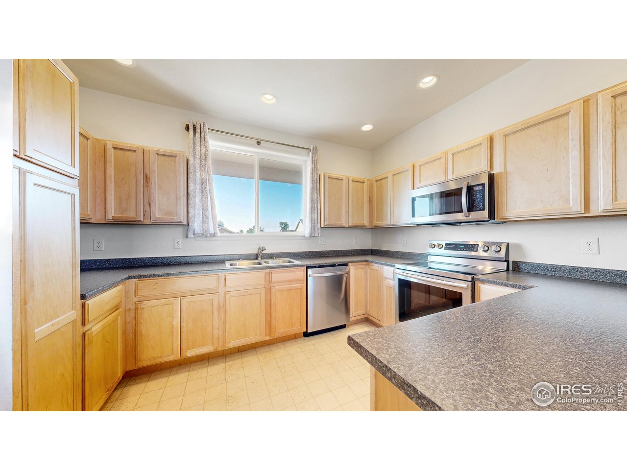 684 Takin Drive Severance, CO 80550 - Photo 6 of 38 a kitchen with stainless steel appliances granite countertop a sink stove and microwave