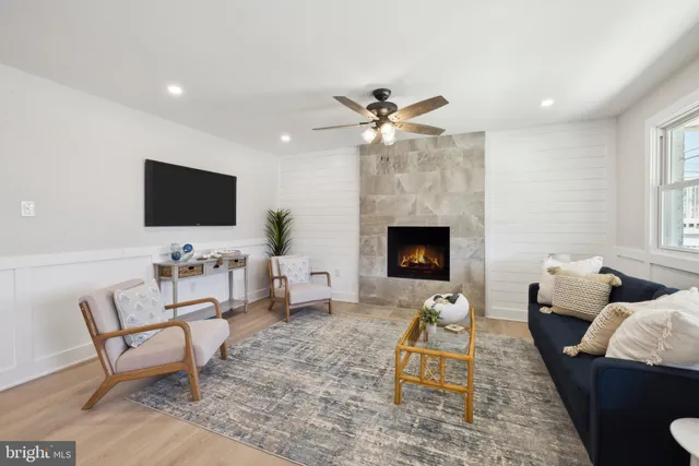 a living room with furniture a fireplace and a flat screen tv