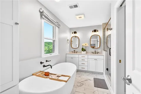 a bathroom with a tub sink and mirror