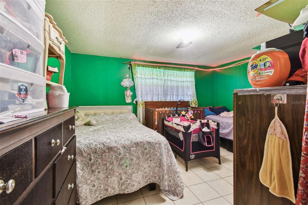 1805 East 139th Avenue, Unit 1 Tampa, FL 33613 - Photo 14 of 44 a bedroom with a bed and a chandelier