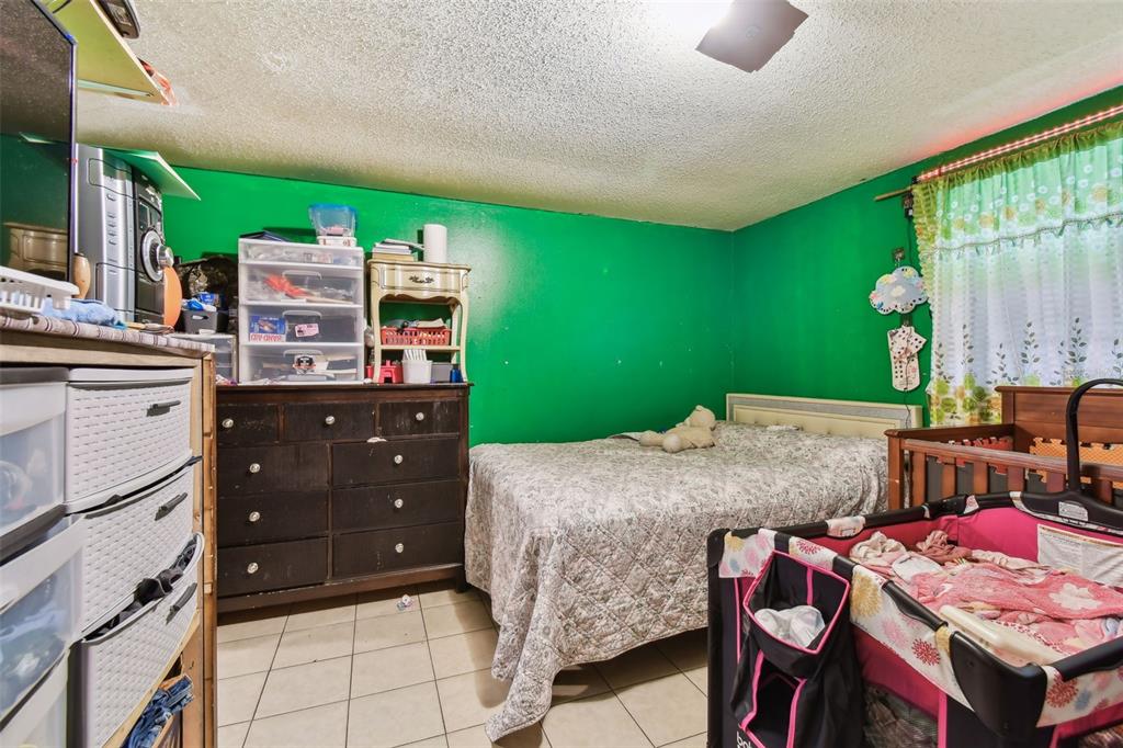 1805 East 139th Avenue, Unit 1 Tampa, FL 33613 - Photo 15 of 44 a bedroom with a bed and a bookshelf