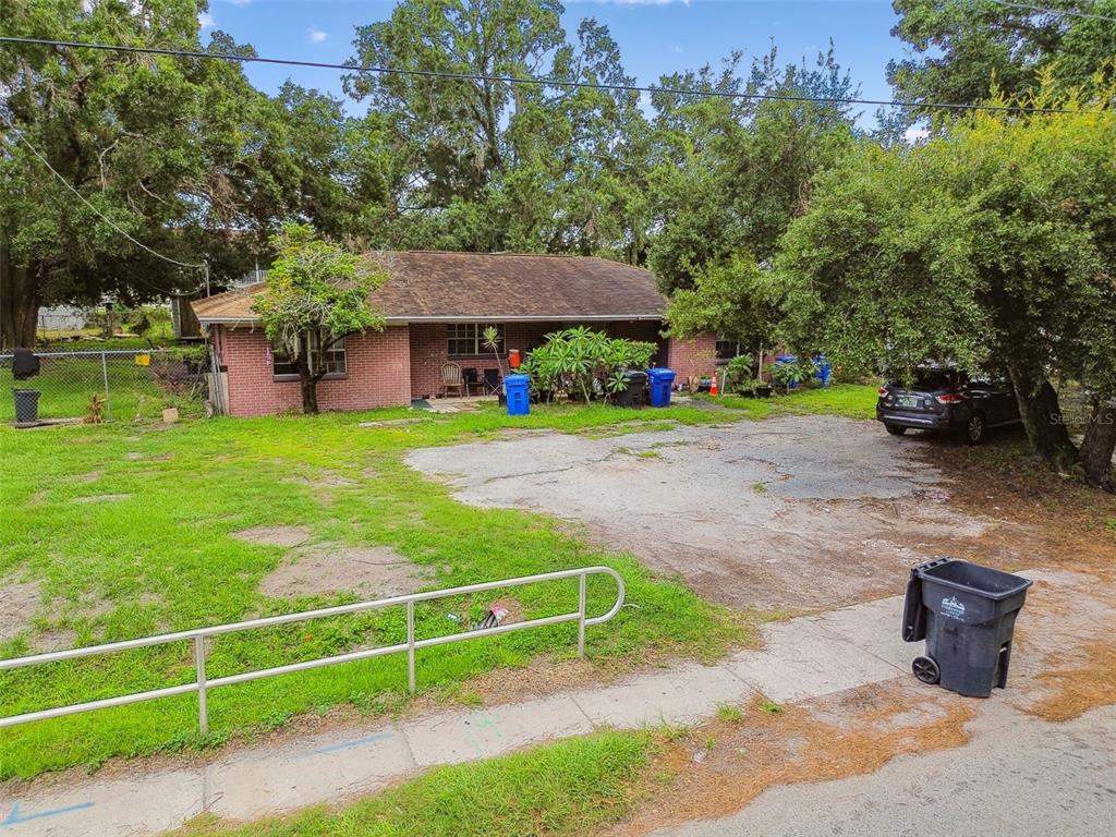 1805 East 139th Avenue, Unit 1 Tampa, FL 33613 - Photo 38 of 44 a view of a backyard with table and chairs potted plants and a palm tree