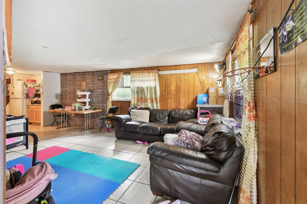 1805 East 139th Avenue, Unit 1 Tampa, FL 33613 - Photo 4 of 44 a living room with furniture and a floor to ceiling window