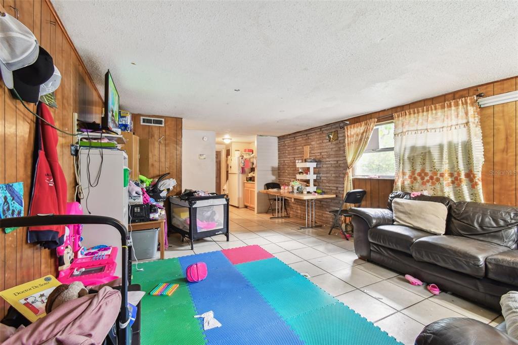 1805 East 139th Avenue, Unit 1 Tampa, FL 33613 - Photo 5 of 44 a living room with furniture and a floor to ceiling window