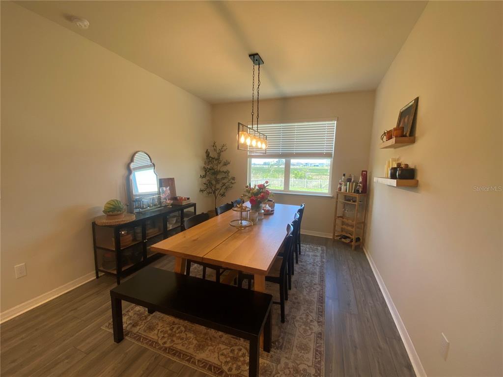 9610 Rally Spring Loop Wesley Chapel, FL 33545 - Photo 5 of 38 a room with a table chairs and wooden floor