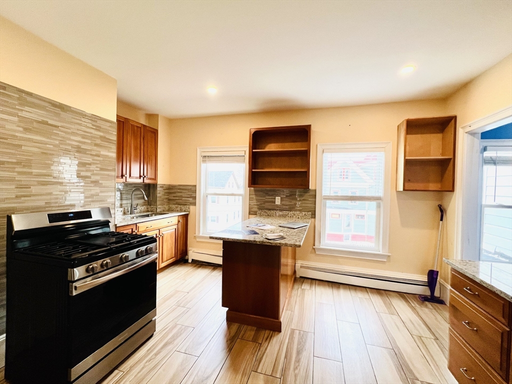 249 Chatham Street Lynn, MA 01902 - Photo 11 of 42 a kitchen with a wooden floor and a stove top oven