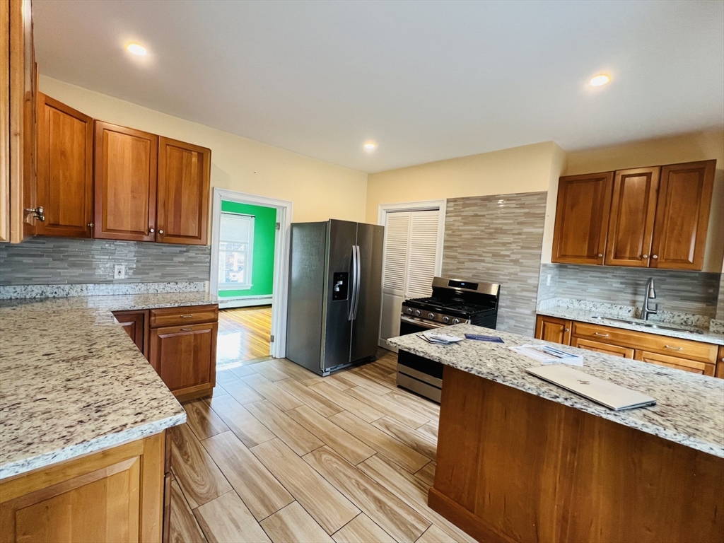 249 Chatham Street Lynn, MA 01902 - Photo 13 of 42 a kitchen with stainless steel appliances granite countertop a sink stove and refrigerator