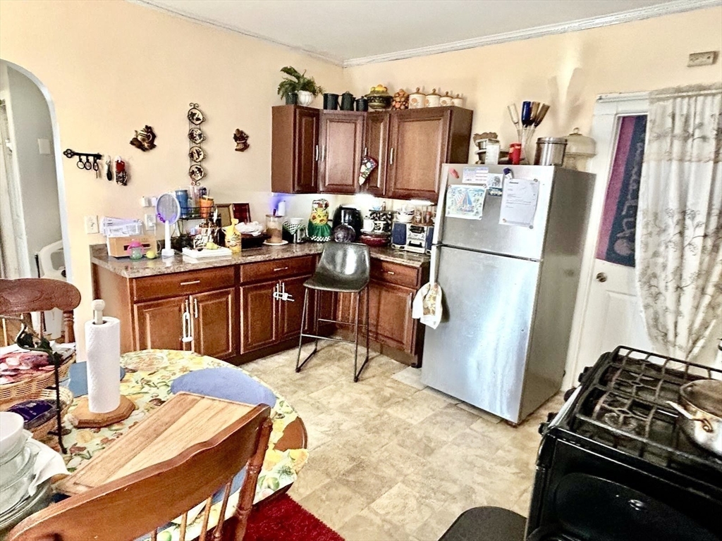 249 Chatham Street Lynn, MA 01902 - Photo 27 of 42 a kitchen with stainless steel appliances a stove a refrigerator a sink a dining table and chairs