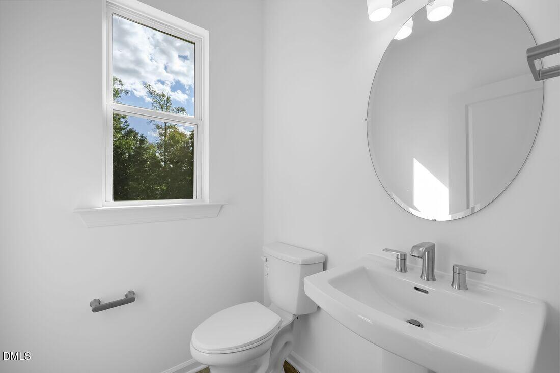 430 Rowe Way Knightdale, NC 27545 - Photo 16 of 51 a bathroom with a toilet a sink a mirror and a window