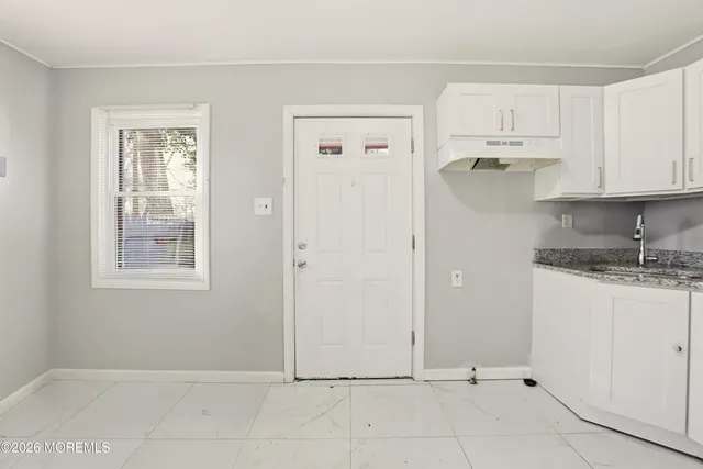 a view of kitchen with granite countertop cabinets