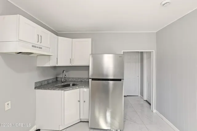 a kitchen with a refrigerator sink stove and cabinets
