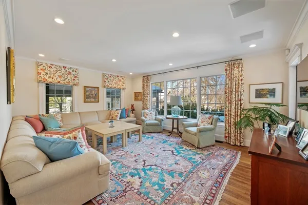 a living room with furniture a rug and a floor to ceiling window