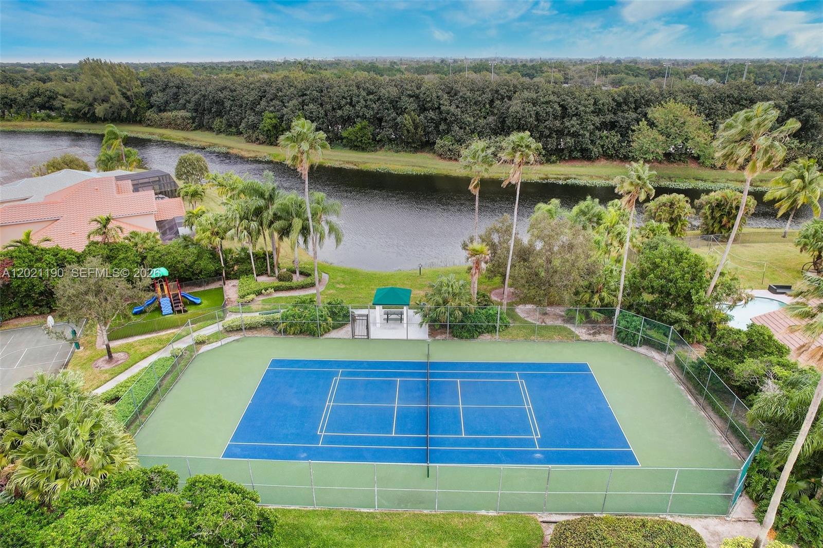 814 Heron Road Weston, FL 33326 - Photo 27 of 27 a view of a swimming pool with a yard and large tree